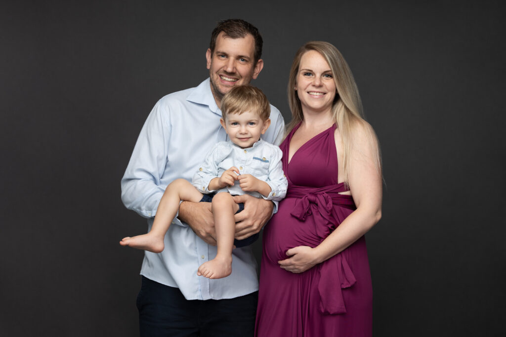 Eine Familie bei einem Babybauch Shooting in Wien in einem Fotostudio.