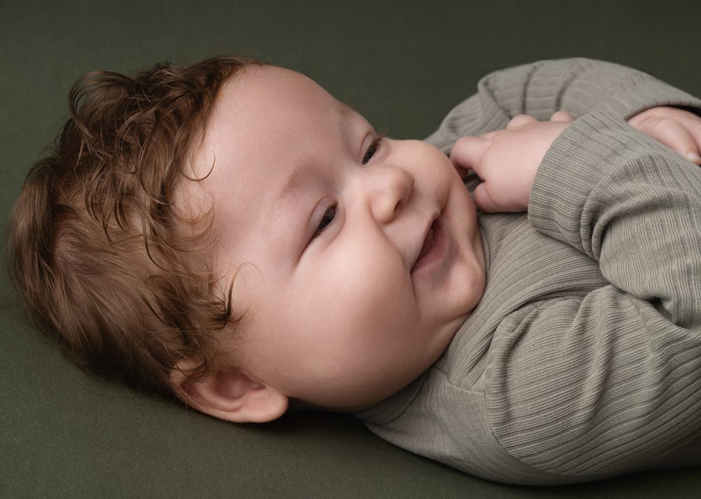 Ein lächelndes Baby bei einem Fotoshooting.